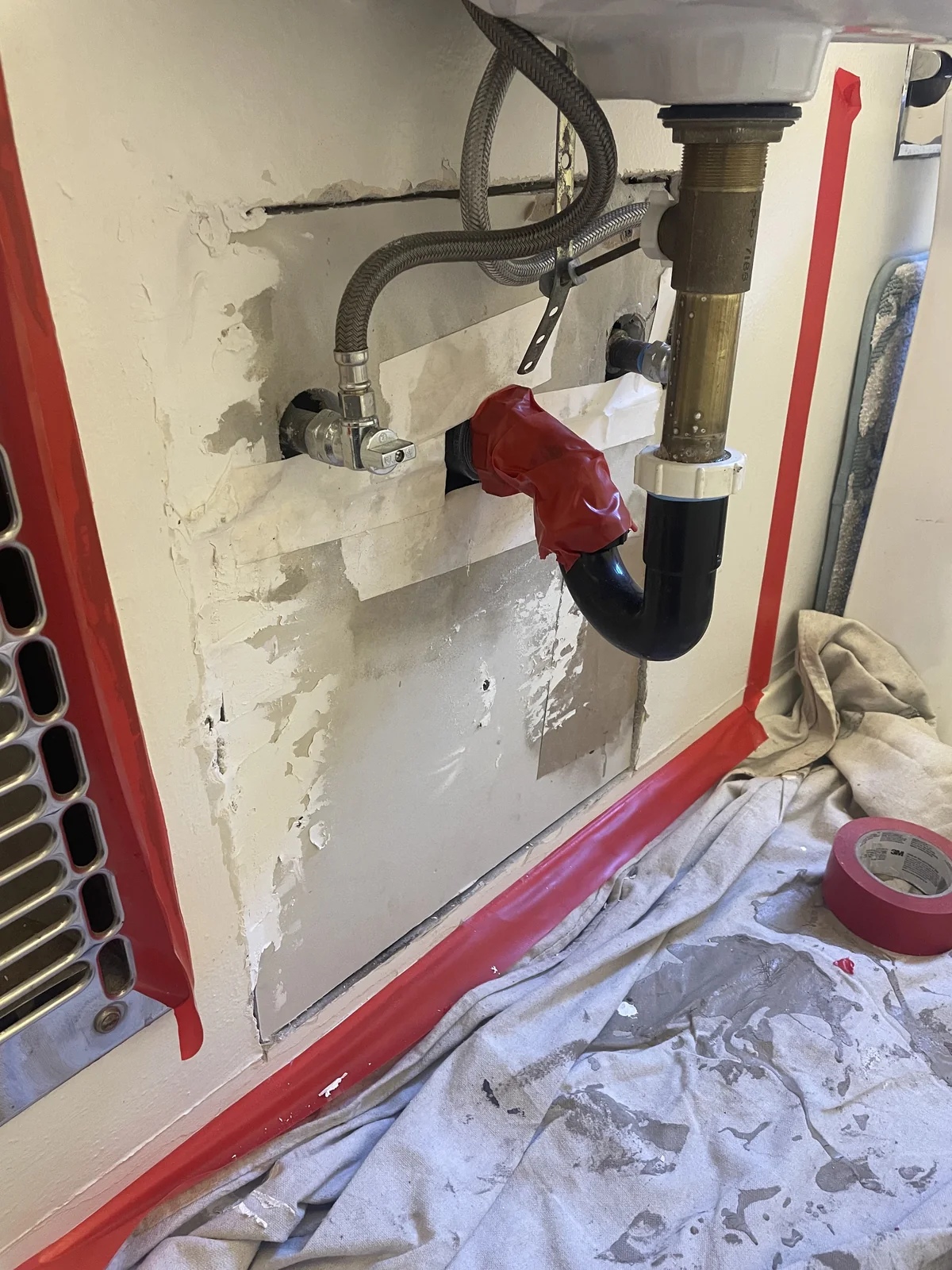 Protected sink plumbing work area with tape and floor protection